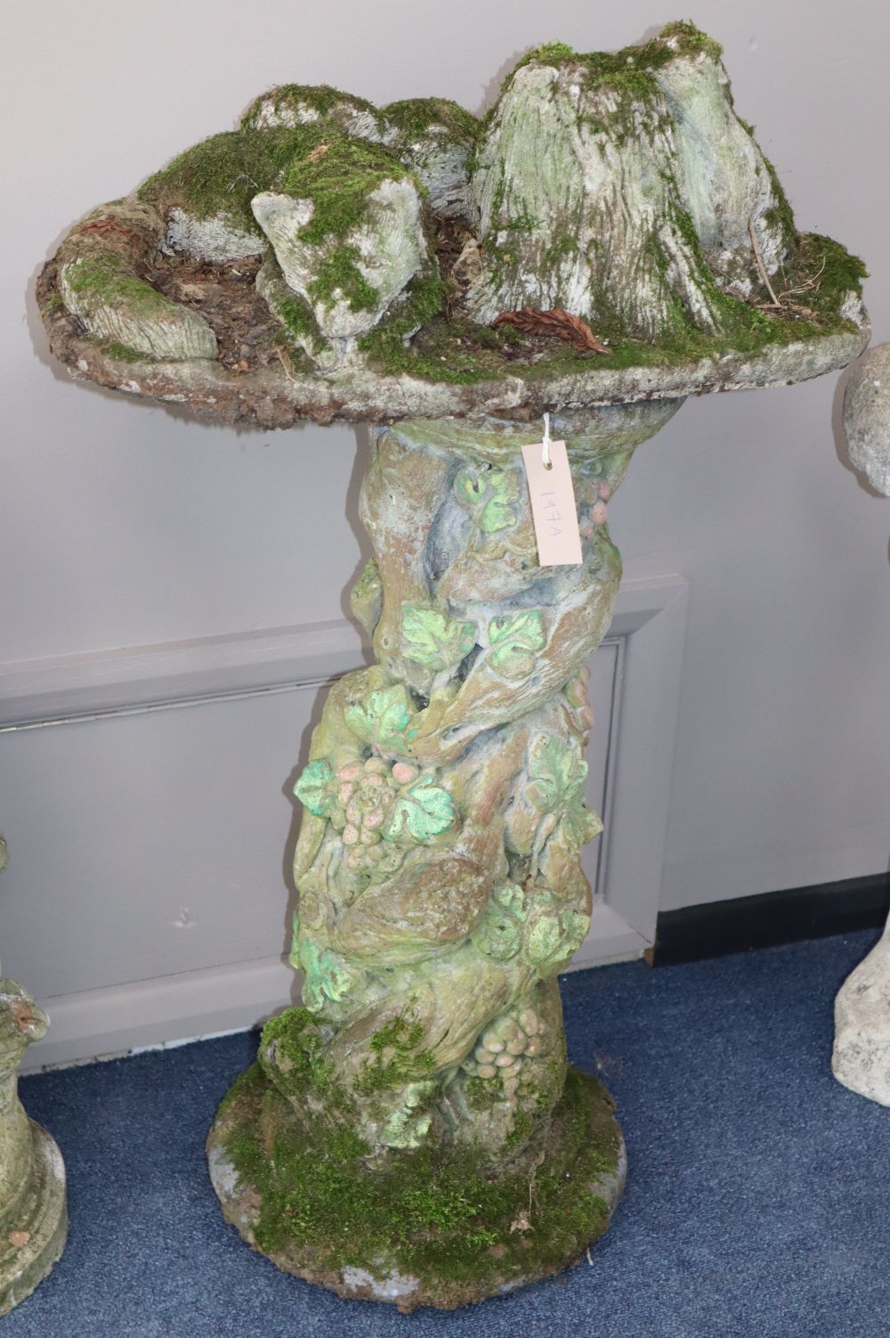 A reconstituted stone garden ornament of a fox beside stump, H.83cm